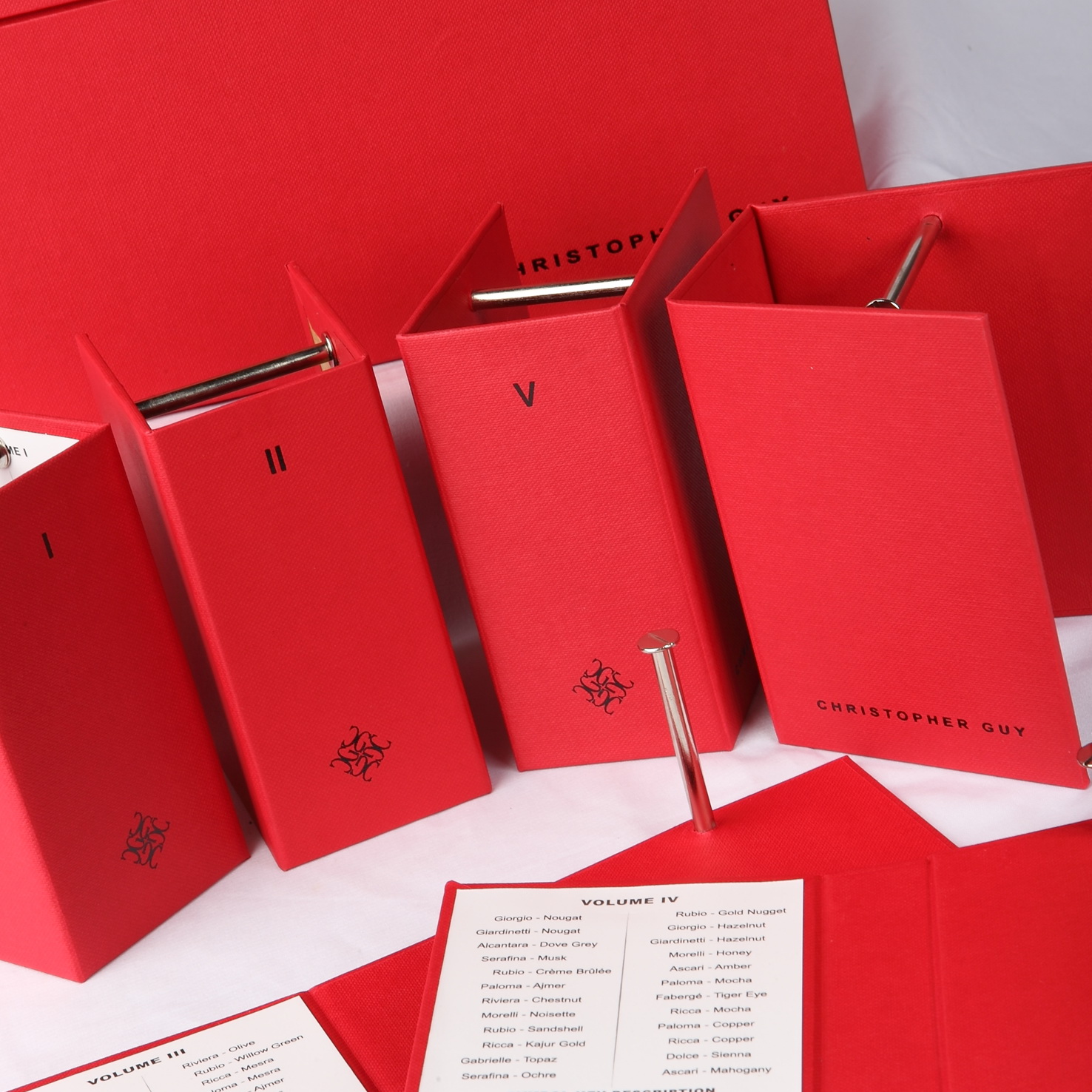 Material board showing linen, leatherette, and wood veneer swatches with foil and hardware samples